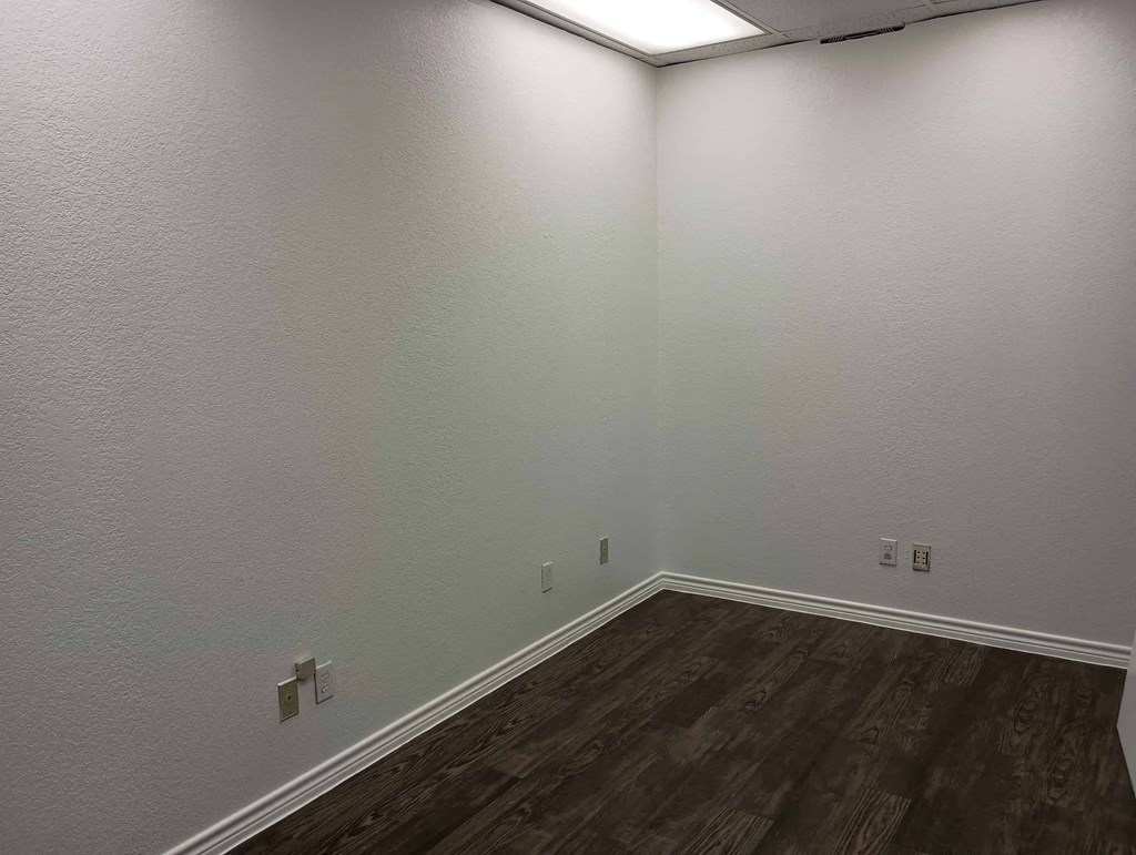 a empty room with wooden floors and white walls