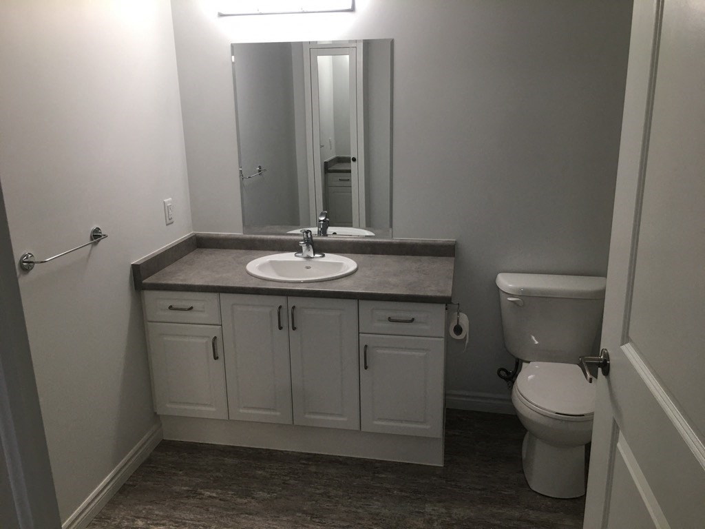 a bathroom with a sink toilet and a mirror