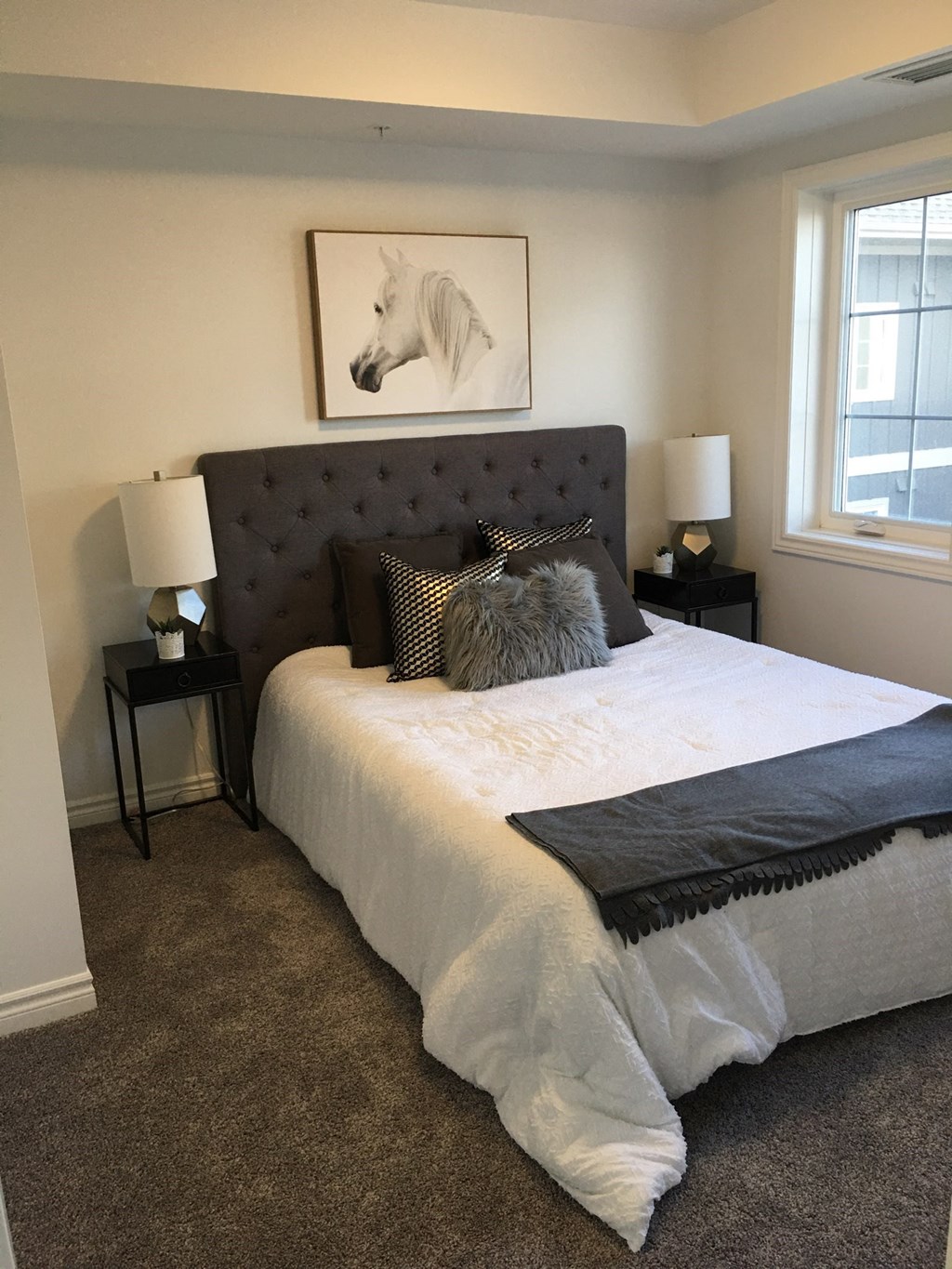 a bedroom with a bed and a painting of a white horse