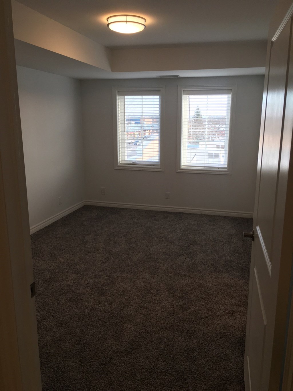 a bedroom with a carpeted floor and three windows