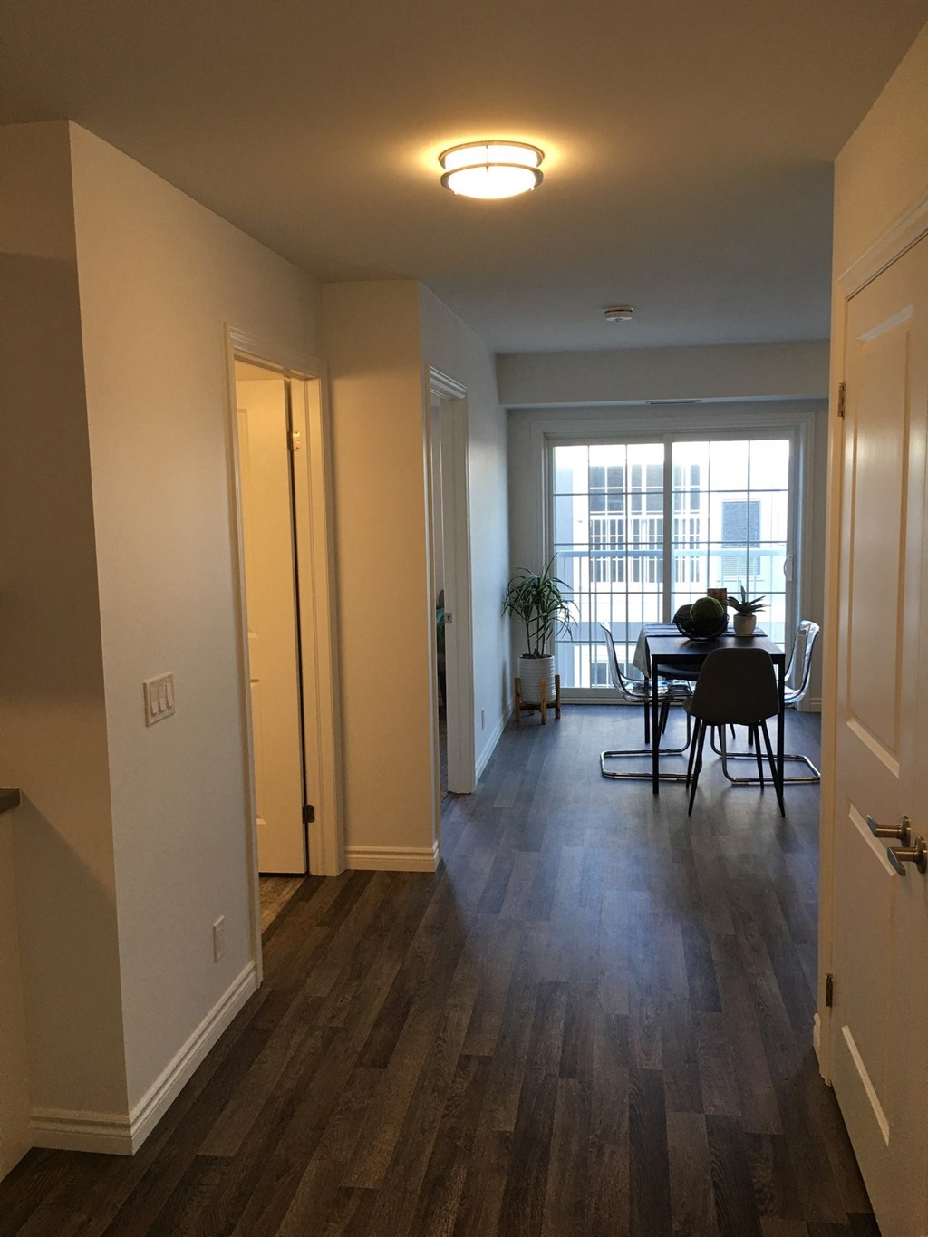 an empty living room with a dining room table and a window