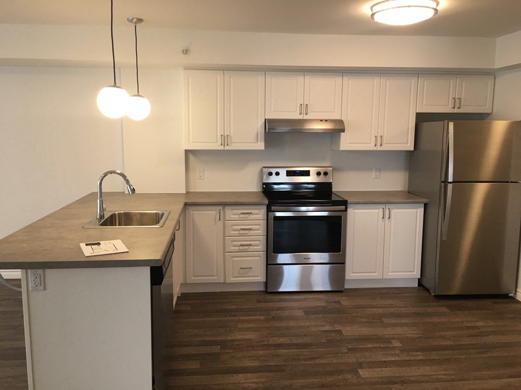 a kitchen with white cabinets and stainless steel appliances