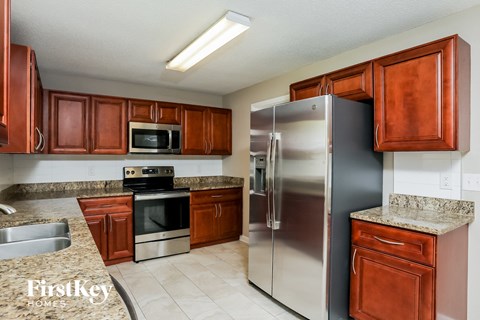 A kitchen with brown cabinets and a stainless steel refrigerator.