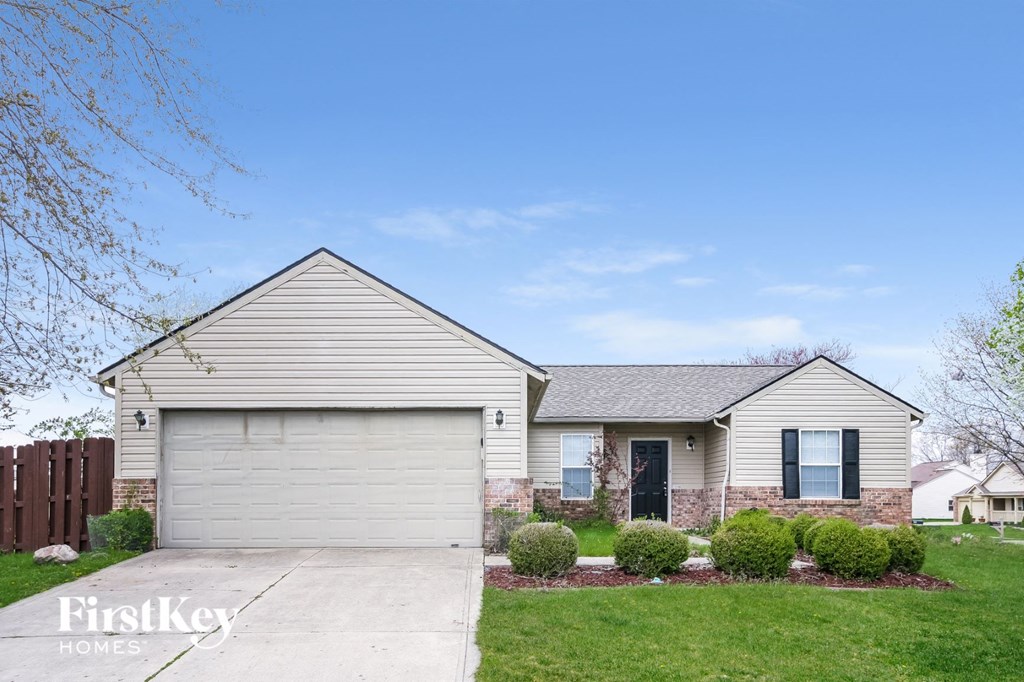 a white and brick house with a white garage door