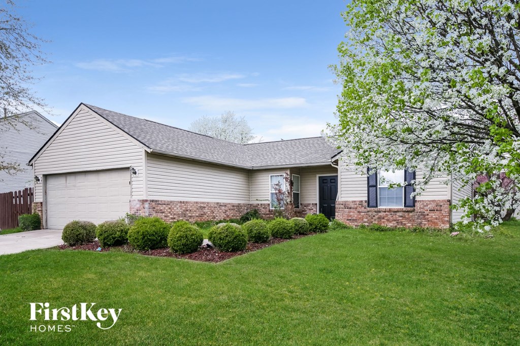 a white house with a lawn and a driveway