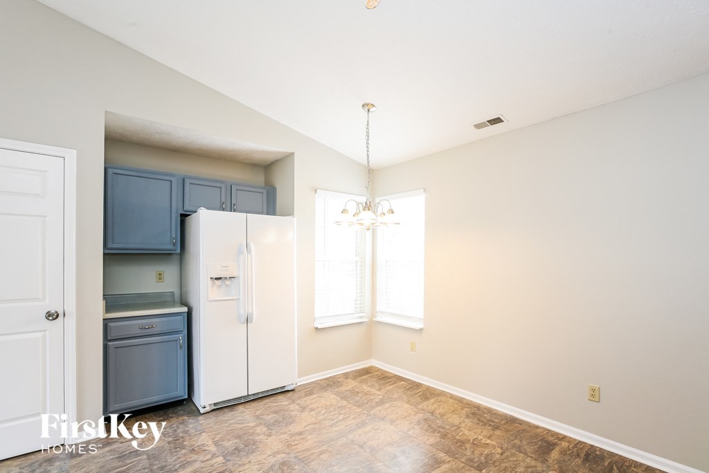 a kitchen with blue cabinets and a white refrigerator