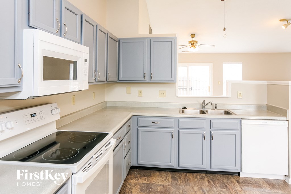 a kitchen with white appliances and blue cabinets