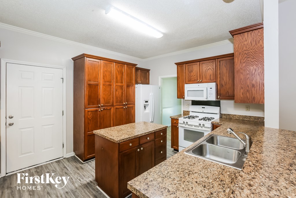 A kitchen with granite countertops and wooden cabinets.