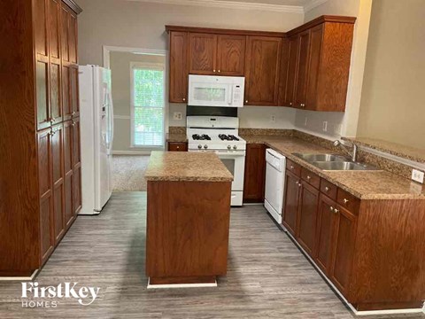 A kitchen with wooden cabinets and a granite countertop.