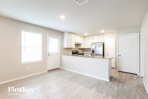 A kitchen area with a refrigerator, microwave, and oven.