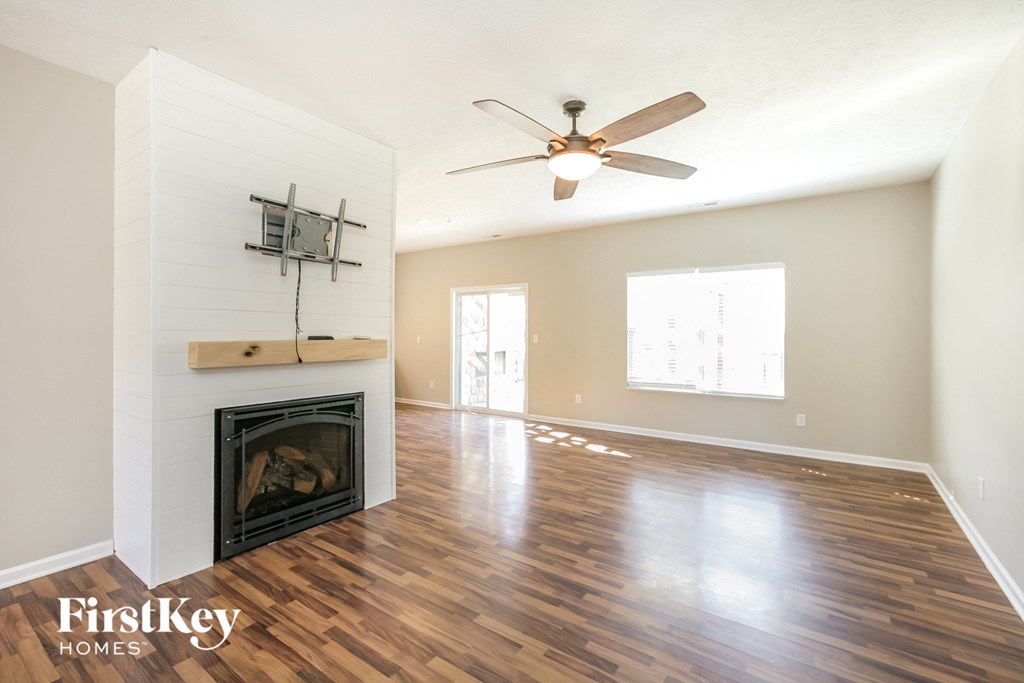 a living room with a fireplace and a ceiling fan