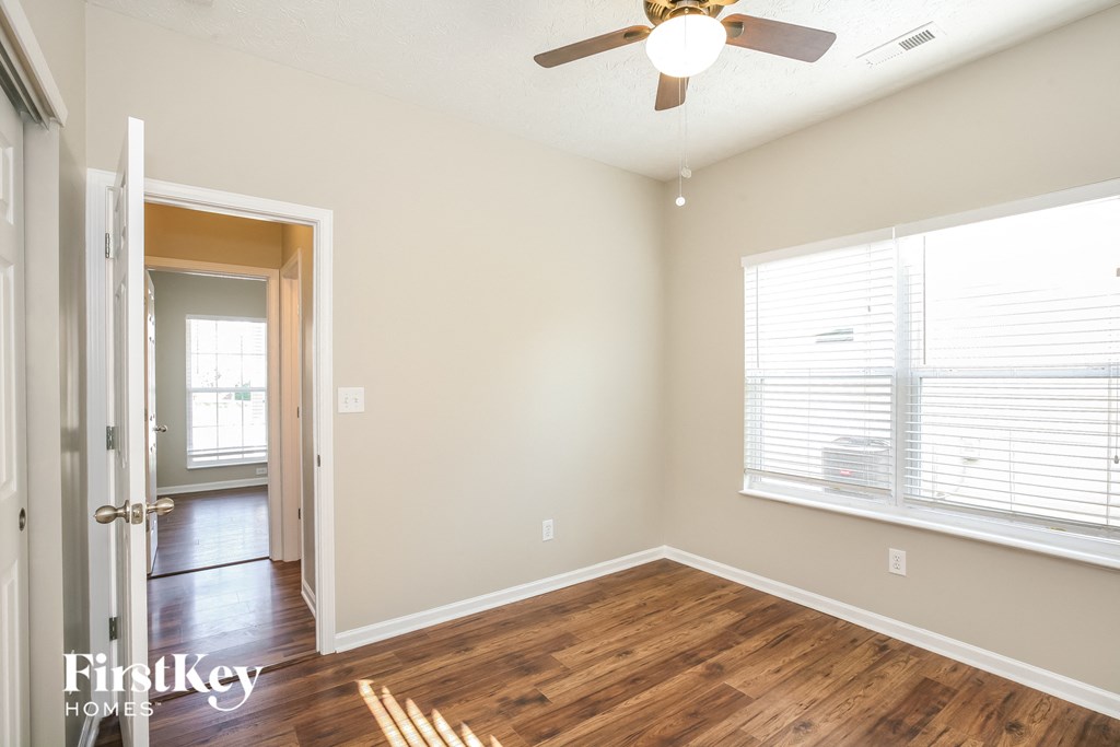 a living room with wood floors and a ceiling fan