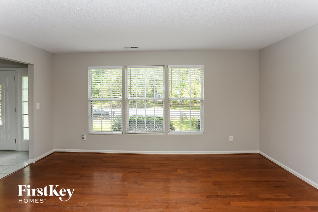 a living room with wood floors and a large window