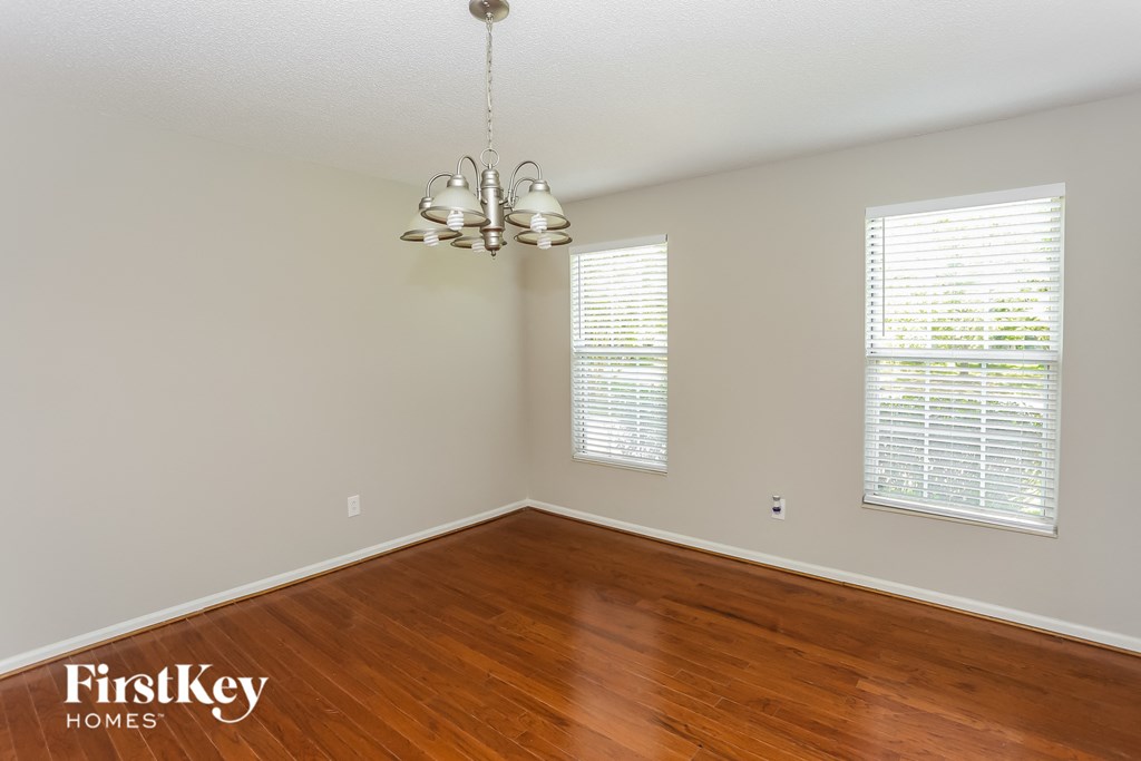 a bedroom with wood floors and white walls and a chandelier