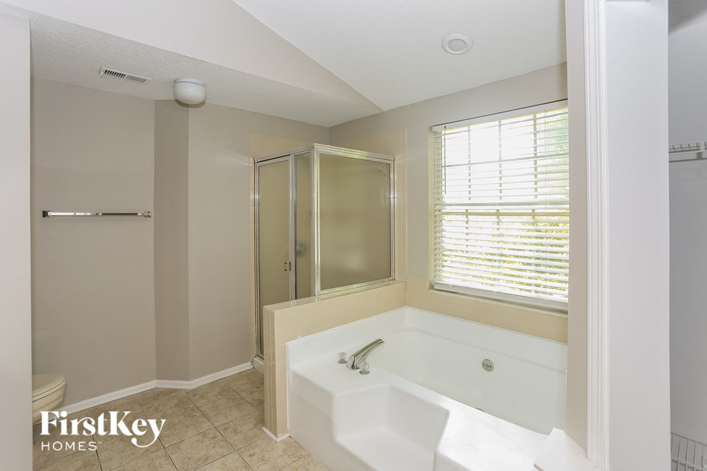 a bathroom with a tub and a shower and a window