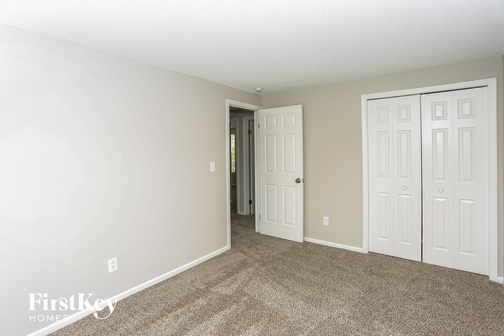 a bedroom with two closets and a door to a hallway