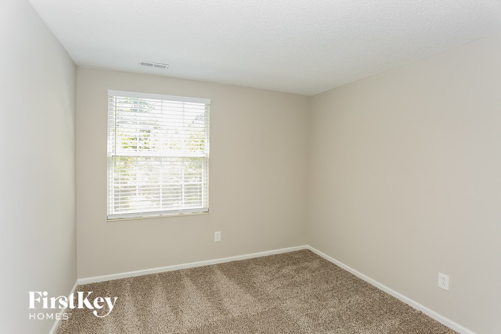 an empty room with carpet and a window