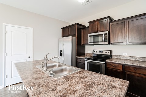 a kitchen with brown cabinets and granite counter tops and a sink