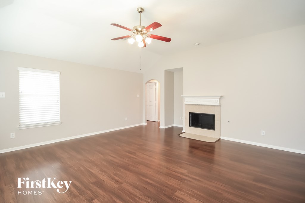 a living room with a fireplace and a ceiling fan