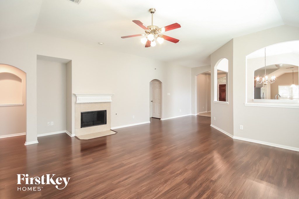 a living room with a fireplace and a ceiling fan