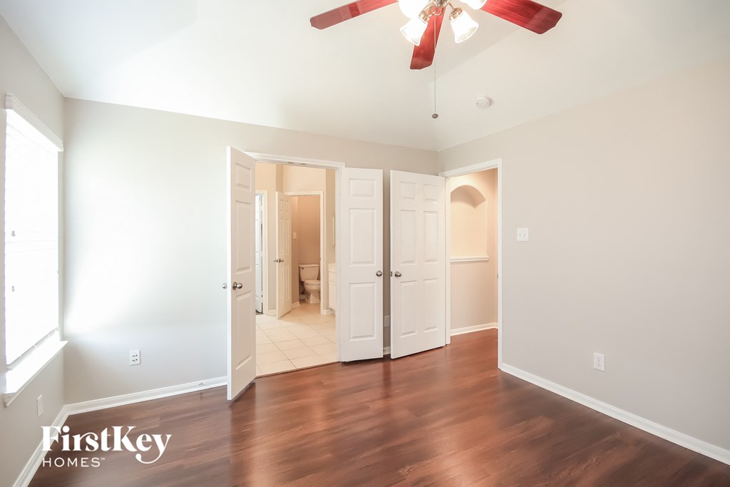 a living room with wood floors and a ceiling fan
