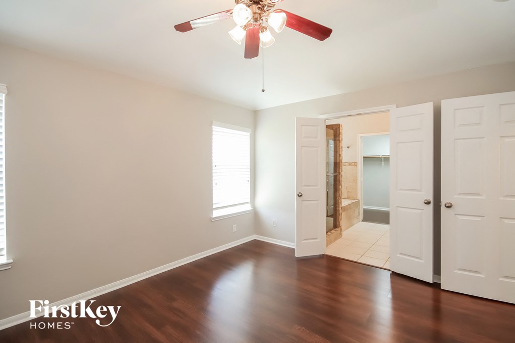 a living room with wood floors and a ceiling fan