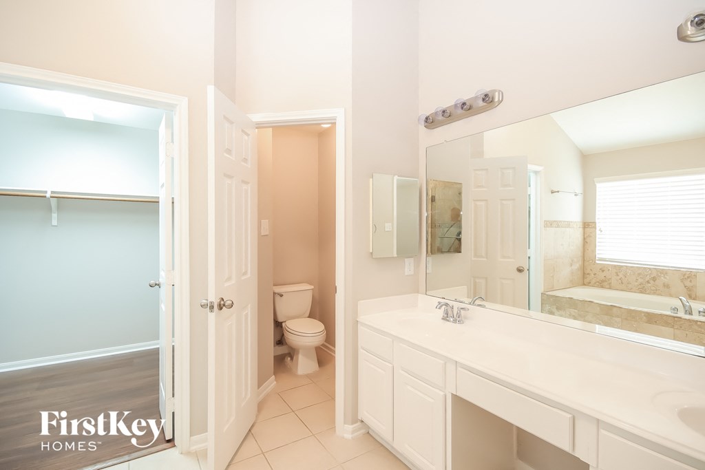 a bathroom with a large mirror and a sink and a toilet