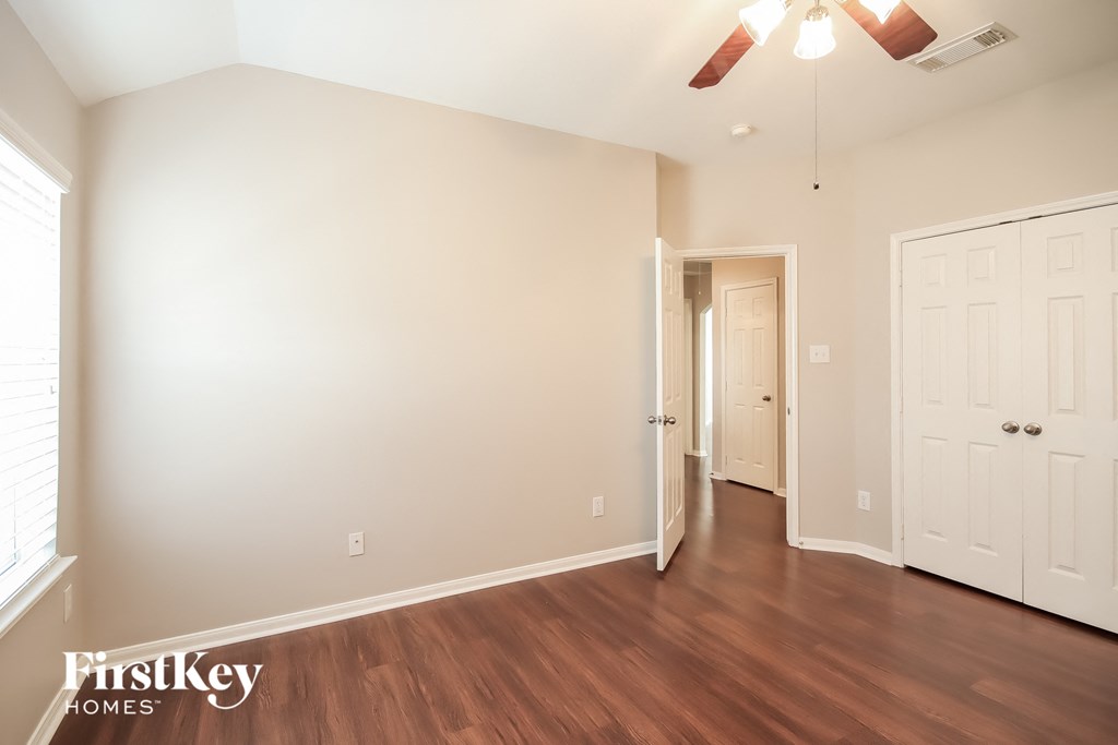 a living room with wood flooring and a ceiling fan