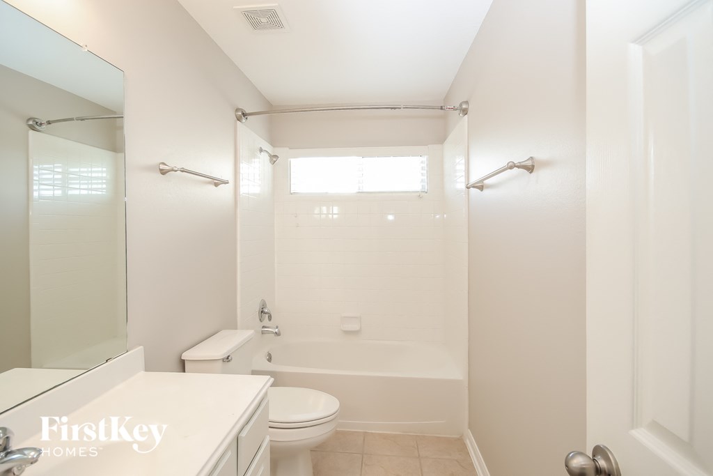 a white bathroom with a tub and a toilet and a sink