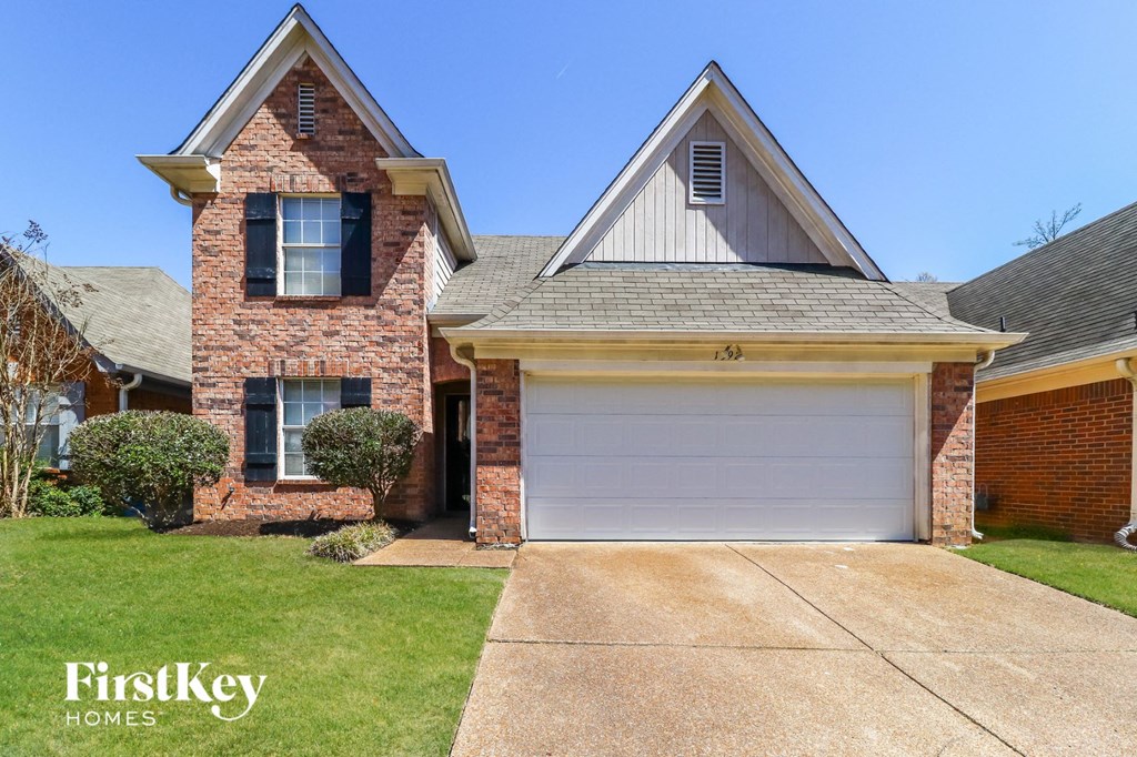 a brick house with a white garage door in front of it