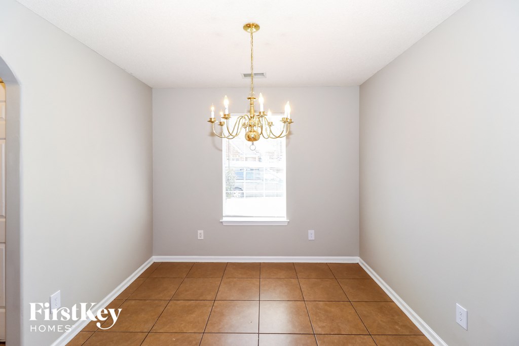 a dining room with a chandelier and a window