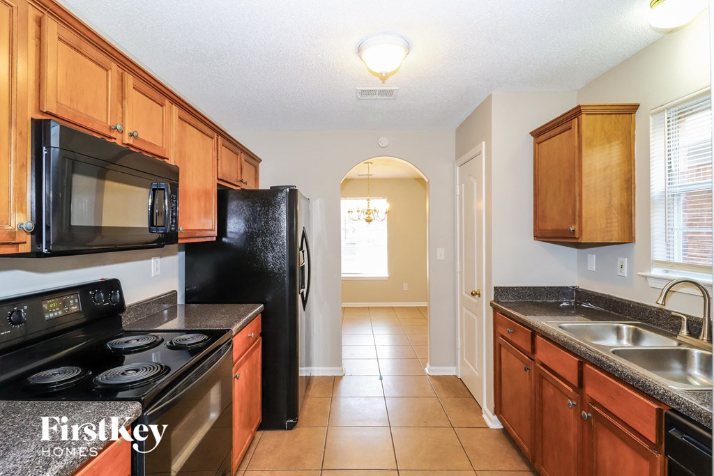 a kitchen with black appliances and wooden cabinets