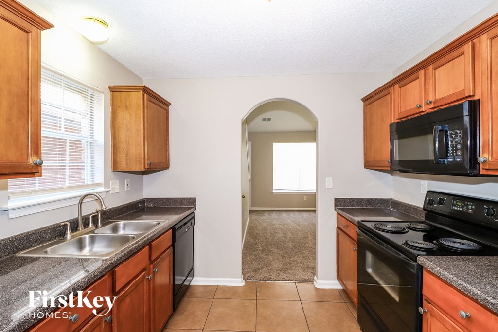 a kitchen with black appliances and wooden cabinets