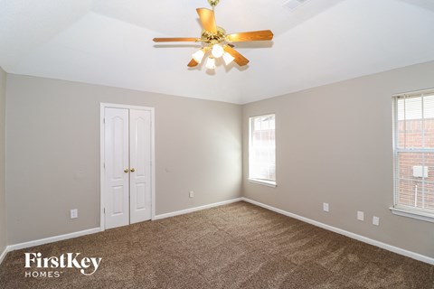 the living room of a home with a ceiling fan and carpet