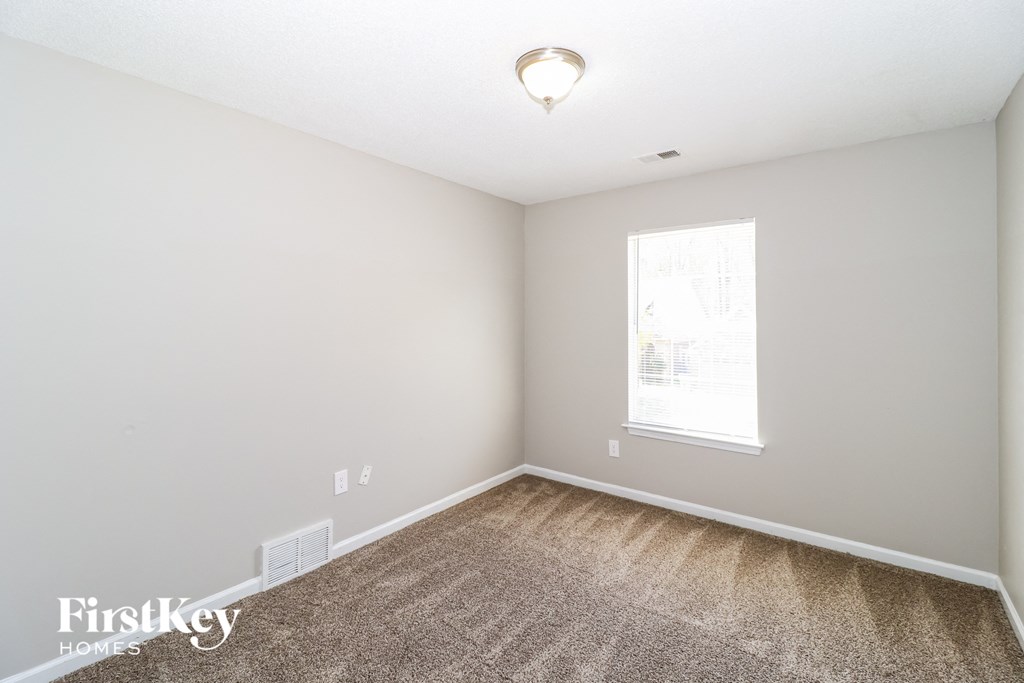 a bedroom with a carpeted floor and a window
