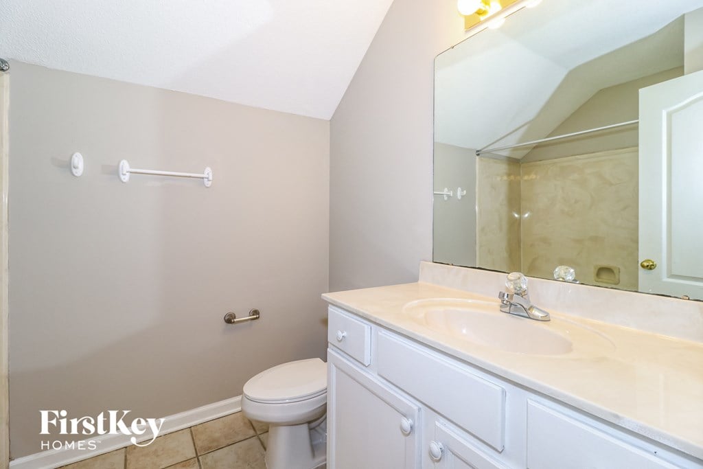 a bathroom with a sink toilet and a mirror