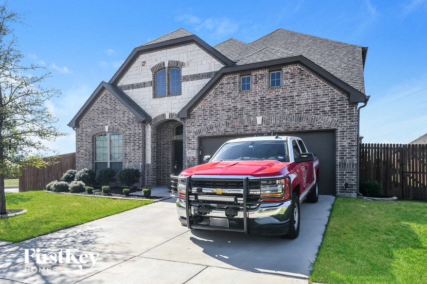 a truck parked in a driveway in front of a house