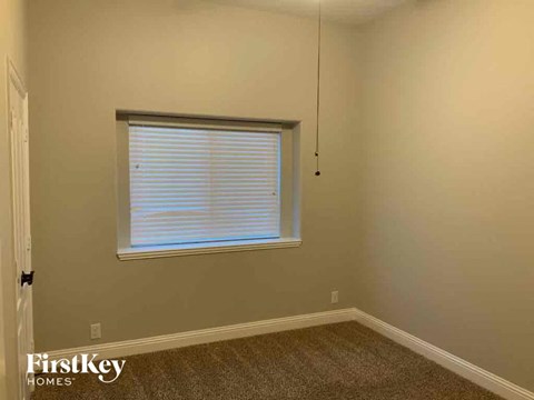 a bedroom with a window and a hanging light