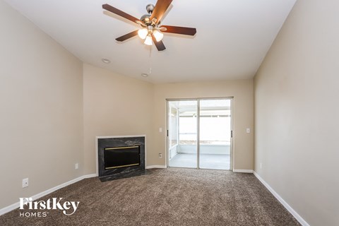 a living room with a fireplace and a ceiling fan