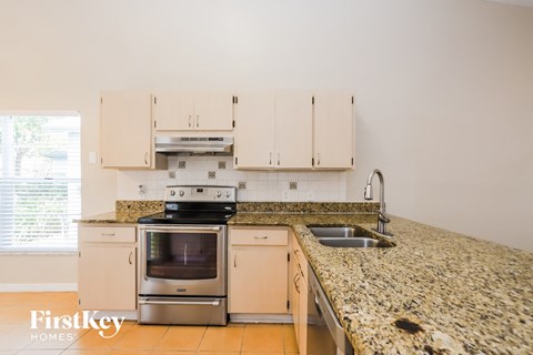 a kitchen with granite counter tops and white cabinets