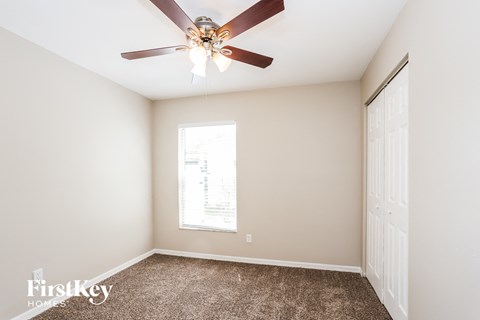 a bedroom with a ceiling fan and a window