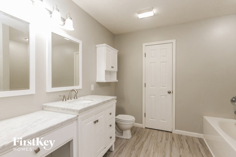 a bathroom with a toilet and a sink and a mirror