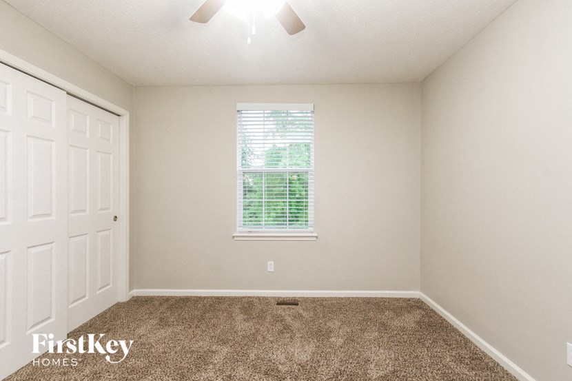 an empty room with a window and a white door