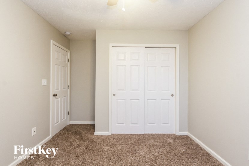 a bedroom with two closets and a carpeted floor