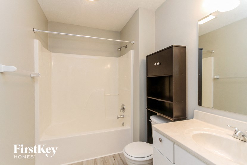 a bathroom with a toilet and a shower and a sink