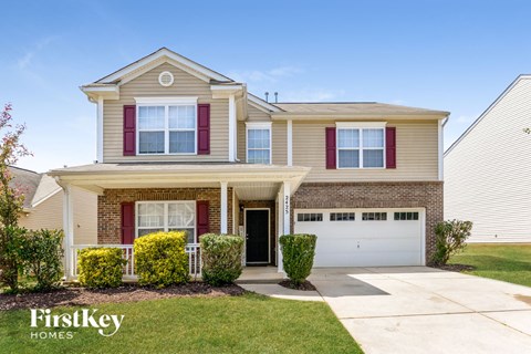 a beige house with red shutters and a white garage door