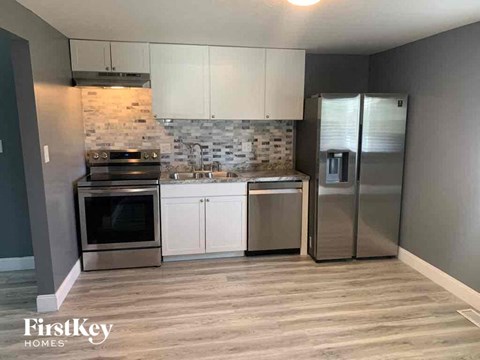 A kitchen with a stove top oven, a dishwasher, and a refrigerator.