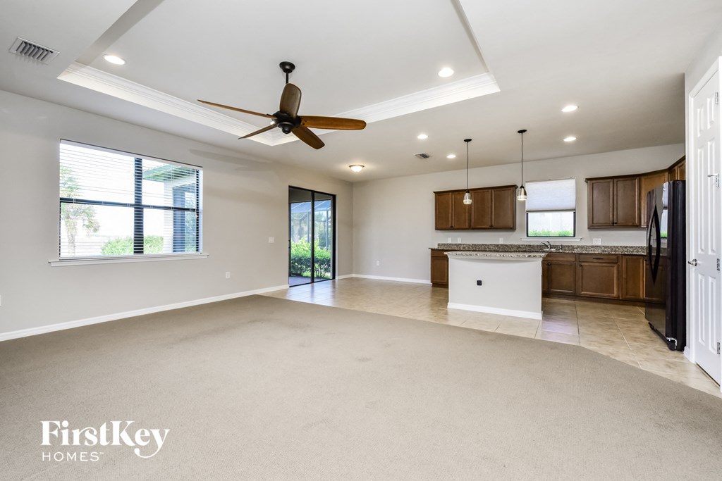 an empty kitchen and living room with a ceiling fan