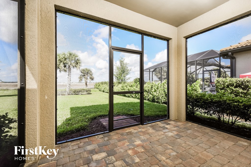 a view of the backyard from the patio of a home with large glass doors