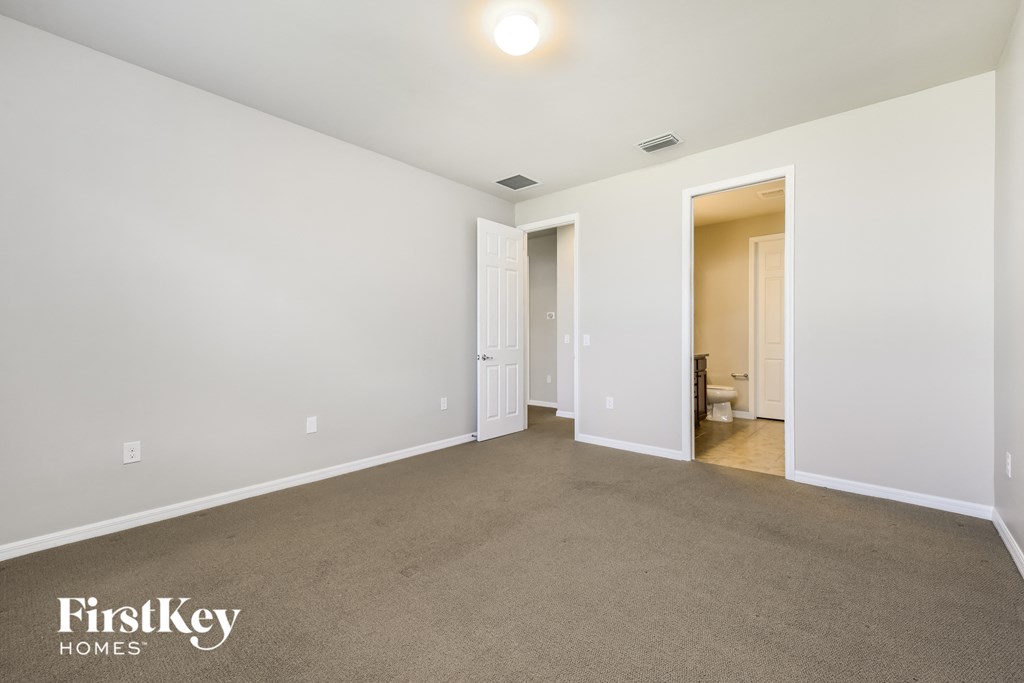 a living room with a carpeted floor and white walls